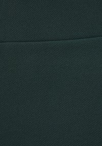 Donkergroen gestructureerde stof met een zachte uitstraling, voorzien van een subtiel geweven patroon. Het oppervlak is glad, zonder zichtbare hardware of accenten.