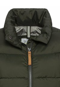 Pufferjacke in dunklem Olivgrün. Verfügt über einen hohen Kragen, einen Frontreißverschluss mit einem Lederzipper und dezente horizontale Nähte.
