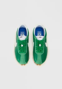 Tênis atléticos verdes com parte superior em couro sintético, logótipo branco e atacadores; palmilha azul com rótulo da marca; sola em borracha de goma.