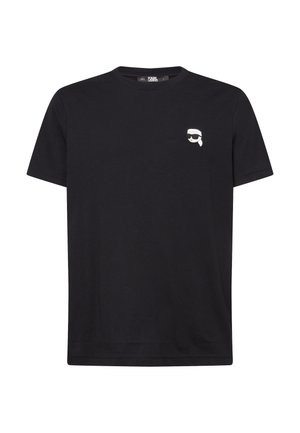 Schwarzes Baumwoll-T-Shirt mit einem kleinen weißen grafischen Gesicht mit Sonnenbrille im linken Brustbereich. Kurzarm und Rundhalsausschnitt-Design.