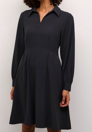 Ciemnoszara sukienka z gładkiej tkaniny, z kołnierzykiem, długimi rękawami oraz rozkloszowaną spódnicą z delikatnymi zakładkami.