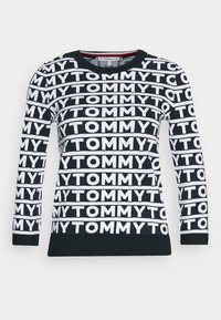 Schwarzer Strickpullover mit weißen "TOMMY"-Text in horizontalen Streifen. Rundhalsausschnitt, lange Ärmel, gerippte Bündchen und Saum. Weiche Textur.