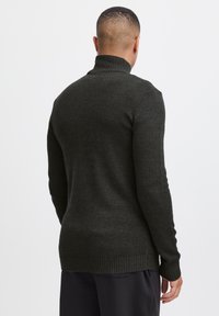Dark gray turtleneck sweater made of textured knit fabric. Features ribbed cuffs and hem, with a fitted back design.
