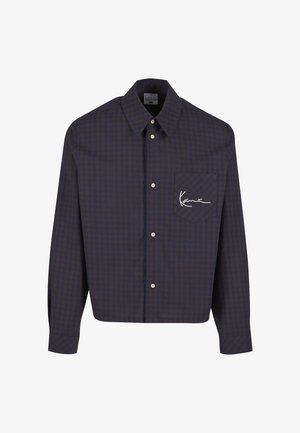 Pikavarrukaga nööbitav särk sinise ja pruuni ruudumustriga, esitasku valge kirjaga logoga ja klassikalise kraega.