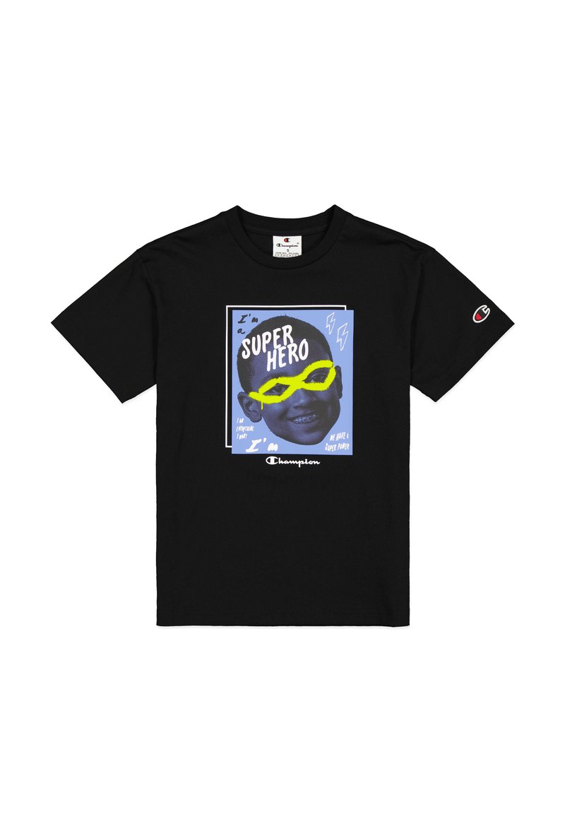 Camiseta de algodón negra con un estampado gráfico que muestra el rostro de un niño, gafas de sol amarillas y un texto en negrita que dice "Soy un SUPER HÉROE" sobre un fondo azul.