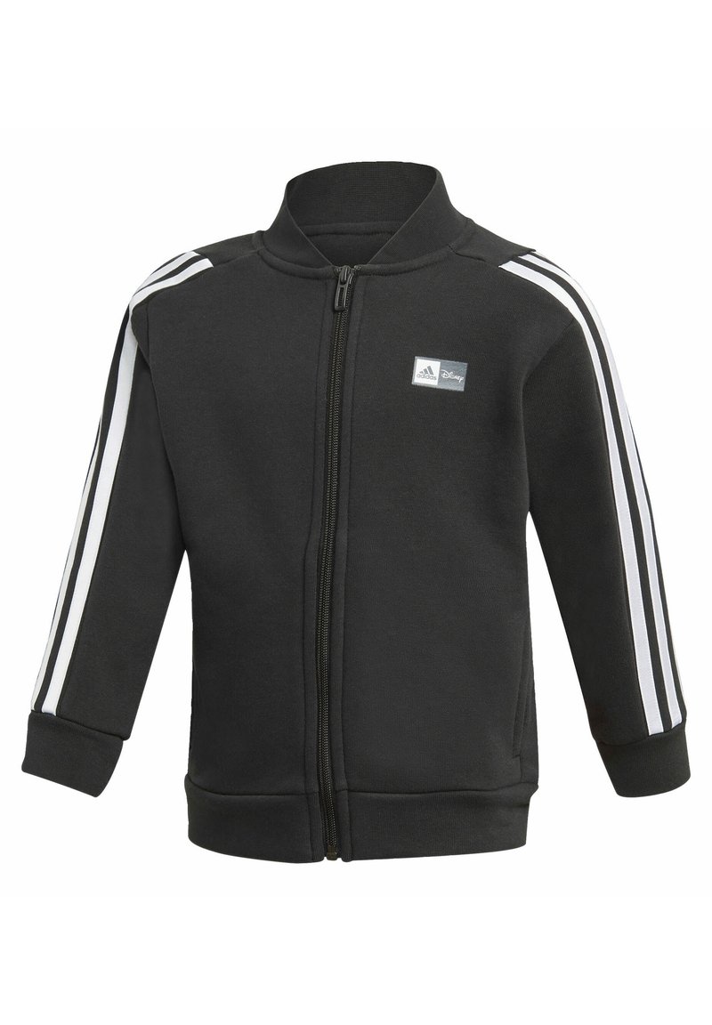 Giacca nera con zip e colletto alto, con strisce bianche lungo le maniche e un piccolo logo sul petto. Tessuto morbido.