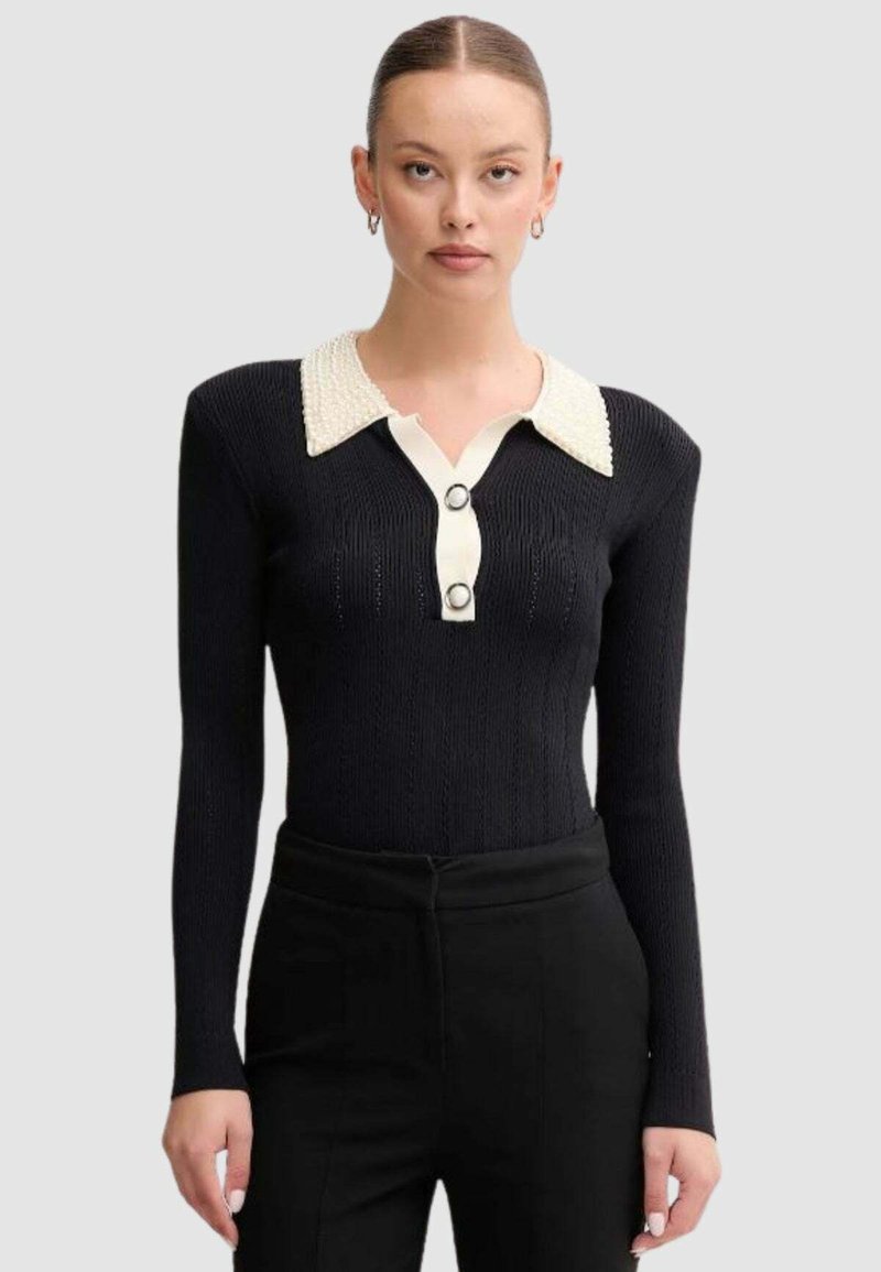 Maglione nero a costine con maniche lunghe, caratterizzato da un colletto bianco testurizzato, due bottoni centrali e una vestibilità sartoriale.