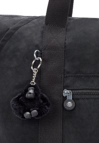 Schwarze Stofftasche mit texturierter Oberflächenbeschaffenheit, ausgestattet mit einem silbernen Kettenanhänger mit einer schwarzen Gorilla-Figur und einer Reißverschlusstasche.