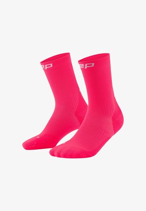 Bright pink athletic socks with a ribbed texture, featuring a white logo at the top and reinforced toe and heel for durability.