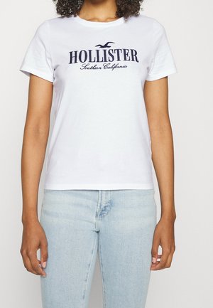 Bílý bavlněný T-shirt s krátkým rukávem, na přední straně s námořnickým modrým textem "HOLLISTER Southern California" a malým logem ptáka.
