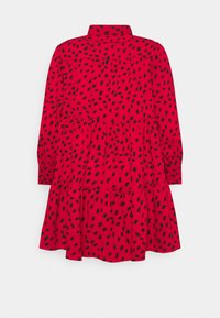 Red dress featuring a tiered design, black abstract spots, long sleeves, and a collared neck. Made of textured fabric with buttoned cuffs.