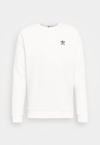 Vit sweatshirt av mjukt material med rund hals och ribbade muddar. Den har en liten svart Adidas-logotyp på bröstet.