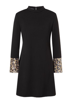 Robe noire à manches longues avec un col montant et des poignets ornés d'un motif léopard, décorée de sequins dorés et argentés.