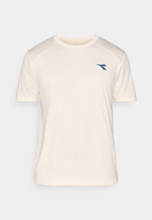 T-shirt de sport beige clair à manches courtes, avec des panneaux d'épaule texturés et un logo bleu sur le devant. Matière douce et évacuant l'humidité.