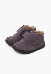 Botines de ante morado con una correa de Velcro, forro suave en color beige, suela de goma negra y detalles cosidos en los laterales.
