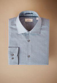 Világoskék kockás ing, széles gallérral, gombolható eleje és mandzsetta részletei vannak. Puha, sima tapintású anyagból készült.