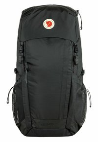 Black nylon backpack with a large main compartment, adjustable straps, mesh side pockets, and a circular logo on the front panel.