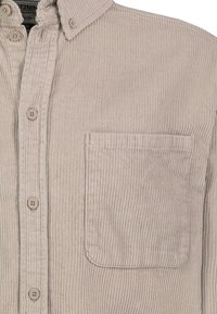 Beige Cord-Hemd mit knöpfbarem Vorderteil, Button-Down-Kragen und einer rechteckigen Brusttasche auf der rechten Seite.