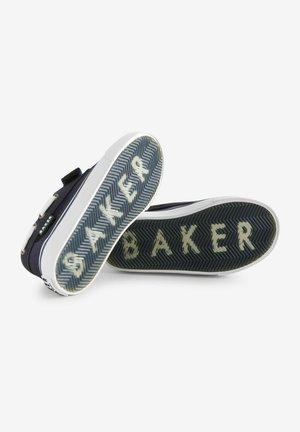 Navy canvas shoes with white rubber soles, featuring a herringbone pattern and "BAKER" in beige on the sole. Hook-and-loop strap closure.