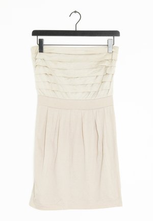 Robe beige sans bretelles avec un buste froncé et une jupe plissée. Fabriquée en tissu léger, elle a une texture lisse et un matériel minimal.