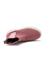 Różowe buty wsuwane z teksturowaną cholewką, elastycznymi bocznymi panelami i białą gumową podeszwą. Wnętrze wykończone jest miękkim materiałem dla większego komfortu.
