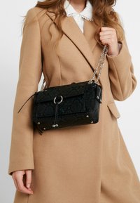 Borsa a tracolla rettangolare con stampa rettile nera e verde, tracolla a catena argento e chiusura a patta con dettaglio ad anello.