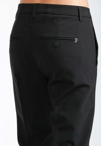 Pantaloni neri su misura con una texture liscia, vestibilità slim e due tasche posteriori con chiusura a bottone e accenti decorativi.