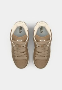 Brown suede sneakers with cream accents, round toe, flat laces, and a padded collar. Features the Fila logo on the tongue and side.