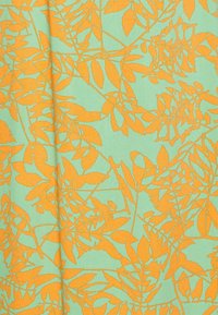 Kangas, jossa on mintunvihreä tausta ja botaaninen kuvio oransseista lehdistä ja oksista, näyttää sileältä ja kevyeltä.