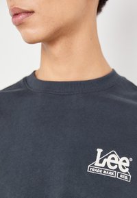 Felicissimo felpa crewneck in cotone blu navy con logo "Lee" ricamato bianco e design montano sul petto. Texture morbida, colletto a coste.