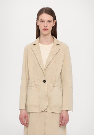 Beige denim blazer, single black button, two front pockets, structured lapel, slightly tailored fit, long sleeves, clean stitching details.
