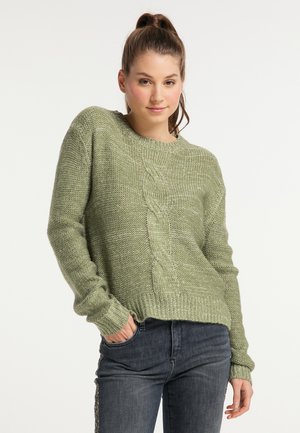 Grøn strikket sweater med lange ærmer og ribbet kant. Har et struktureret kabelstrik design som løber ned ad midten. Bæres med mørke jeans.