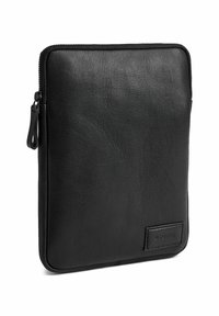Čierny kožený obal na tablet s textúrovaným povrchom, so zipsom a malou dekoratívnou visačkou na spodnej časti. Obdĺžnikový tvar s zaoblenými hranami.