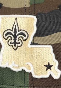 Die Camouflage-Mütze verfügt über eine gestickte Umrisskarte des Bundesstaates Louisiana in Gold mit einer schwarzen Fleur-de-Lis und einem kleinen schwarzen Stern.