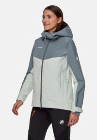 GORE-TEX jakke i lys grå og mørk grå, med hætte, bryst- og sidelommer med lynlås, justerbare manchetter og Mammut-logo.