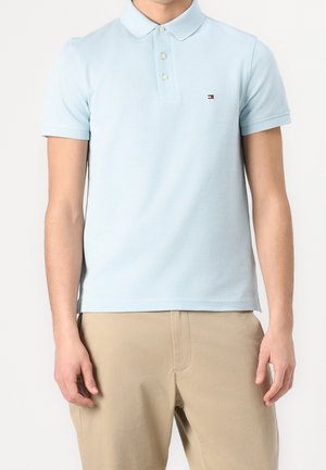  Lichtblauwe polo gemaakt van katoen, met een kraagontwerp, een twee-knopen sluiting en een klein logo op de borst.