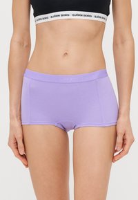 Lila boxer nadrág puha anyagból, varrás nélküli kialakítással és elasztikus derékrésszel, amelyen a "BJÖRN BORG" felirat található.