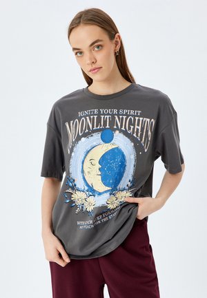 Grijze katoenen t-shirt met een ronde halslijn en korte mouwen, met een blauwe, maan-thema grafiek en bloemaccenten aan de voorkant.