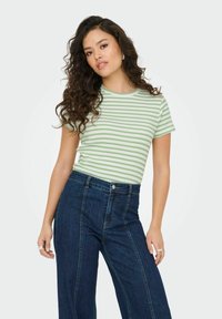 Grøn- og hvidstribet kortærmet t-shirt med rund halsudskæring, parret med højtaljede mørkeblå vide jeans. Glat stofstruktur.