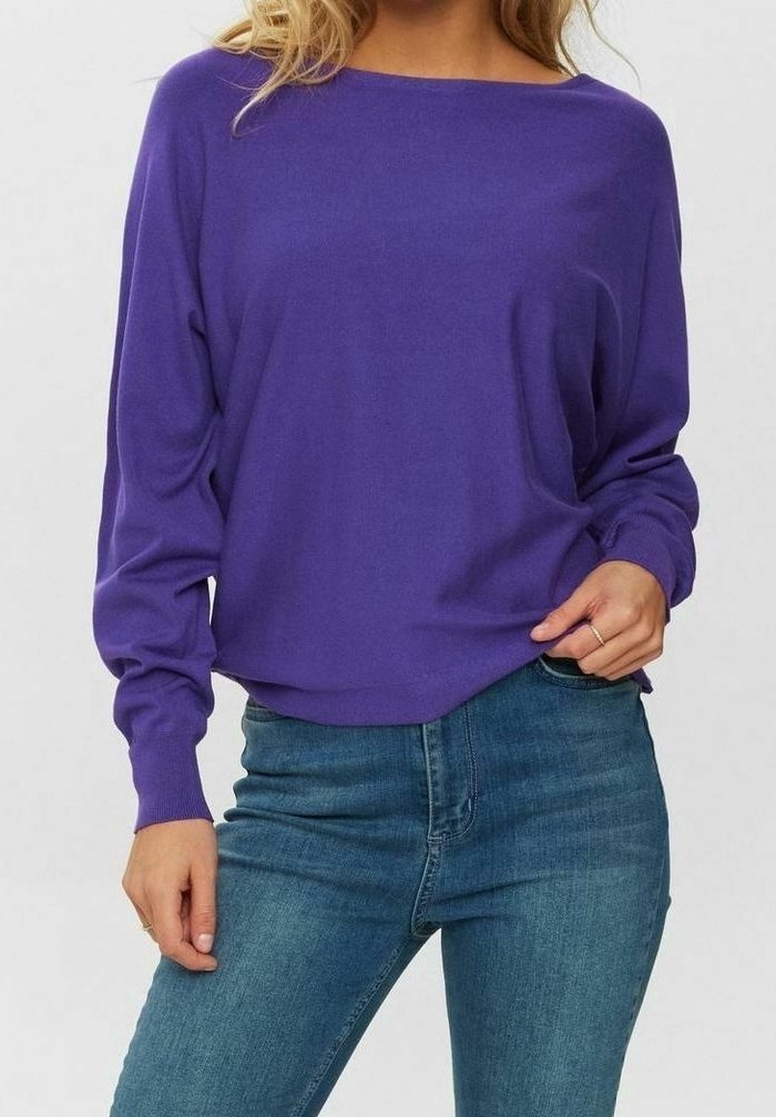 Lila Pullover mit langen Ärmeln und U-Boot-Ausschnitt, locker geschnitten, mit gerippten Bündchen, getragen über blauen Jeans. Weicher Strickstoff, glatte Textur.