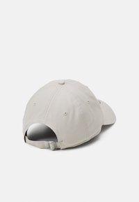 Khaki baseball cap with a curved brim, six-panel structure, and adjustable metal strap at the back; features stitched detailing and ventilation holes.