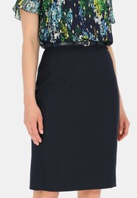 Czarna sukienka o prostym kroju w ciemnoniebieskim kolorze, o gładkiej teksturze, z talią zdobioną małą pętlą na pasek i subtelnym metalowym zapięciem.