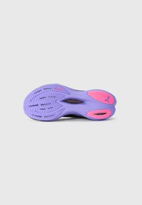 Semelle de chaussure Puma violette et rose avec un profil de première de PUMAGRIP et la caractéristique PWRPLATE au centre sur un fond gris clair.
