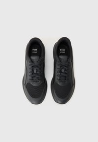 Pantofi sport negri, realizați din piele și plasă, cu un design cu șireturi, suprafață texturată și o talpă din cauciuc cu un model de profil.