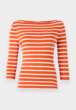 Lange mouwen oranje shirt met horizontale witte strepen en een bootnek. Voorzien van een klein logo op de borst.