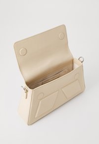 Beige leather handbag with an angled shape, magnetic closure, two exterior pockets, and smooth textured surface. Interior features a card slot.