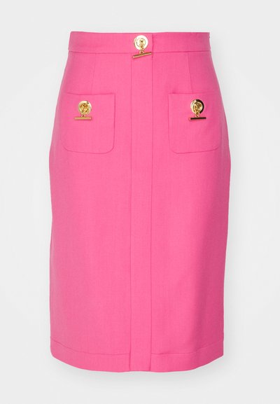 Jupe crayon rose en tissu texturé, dotée de deux poches avec des accessoires en or et d'un détail central en bouton doré au niveau de la taille.