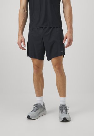 Herre idrettsantrekk som inkluderer svarte shorts med elastisk midje og grå løpesko med teksturerte overflater og polstret såle.