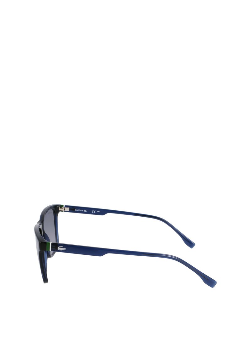 Sunglasses with a navy blue plastic frame, dark tinted lenses, and green accent on the temples. Features a sleek, angular design.