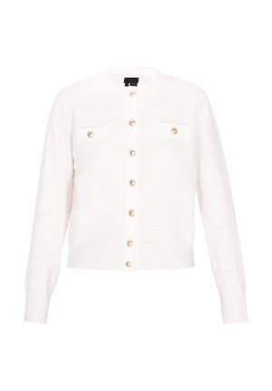 Biała dziergana kardiganka z okrągłym dekoltem, złotymi guzikami i dwoma przednimi kieszeniami. Fakturalne paski zdobią tkaninę.